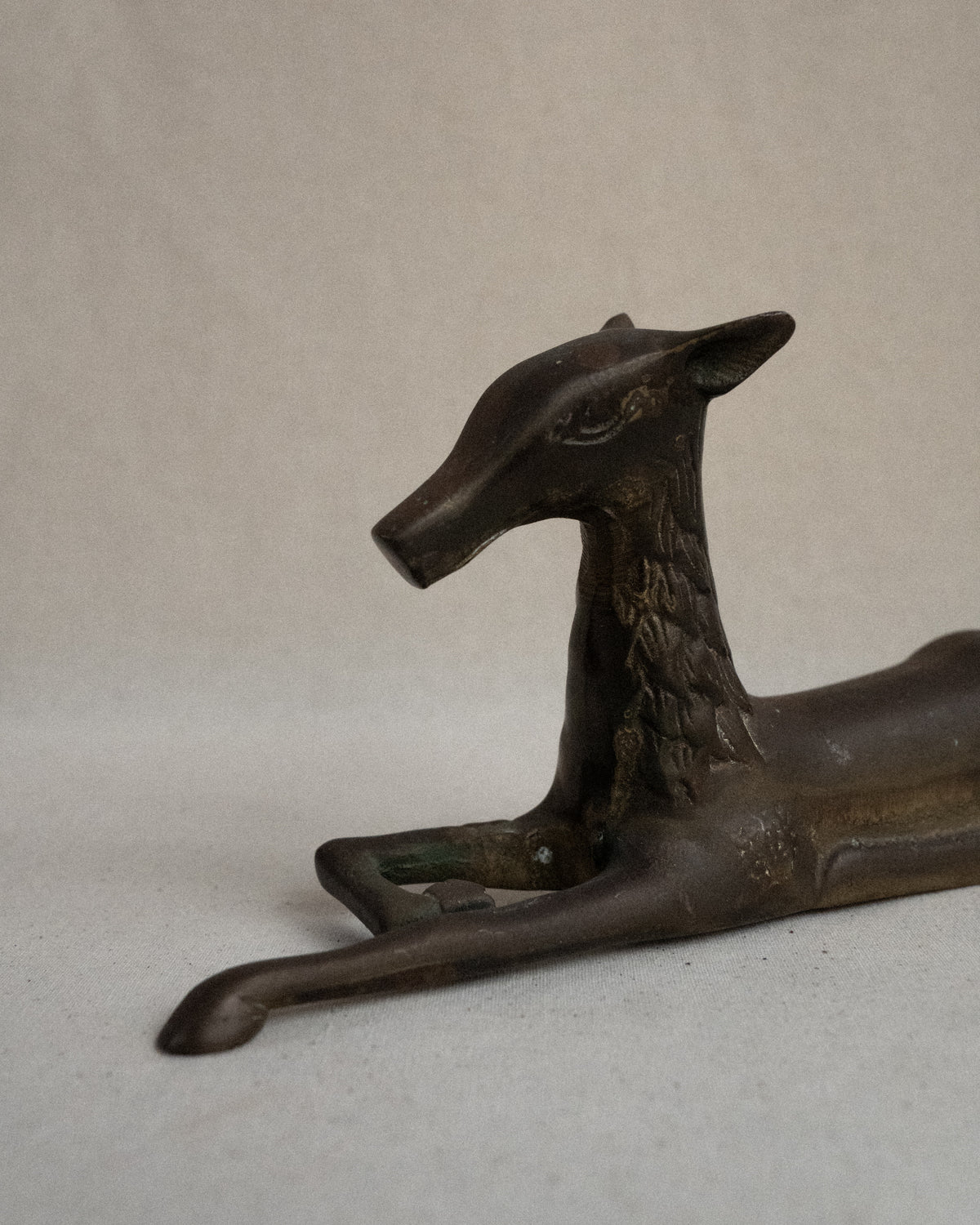 Brass deer sitting sculpture