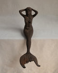 Edge-sitting cast iron mermaid sculpture