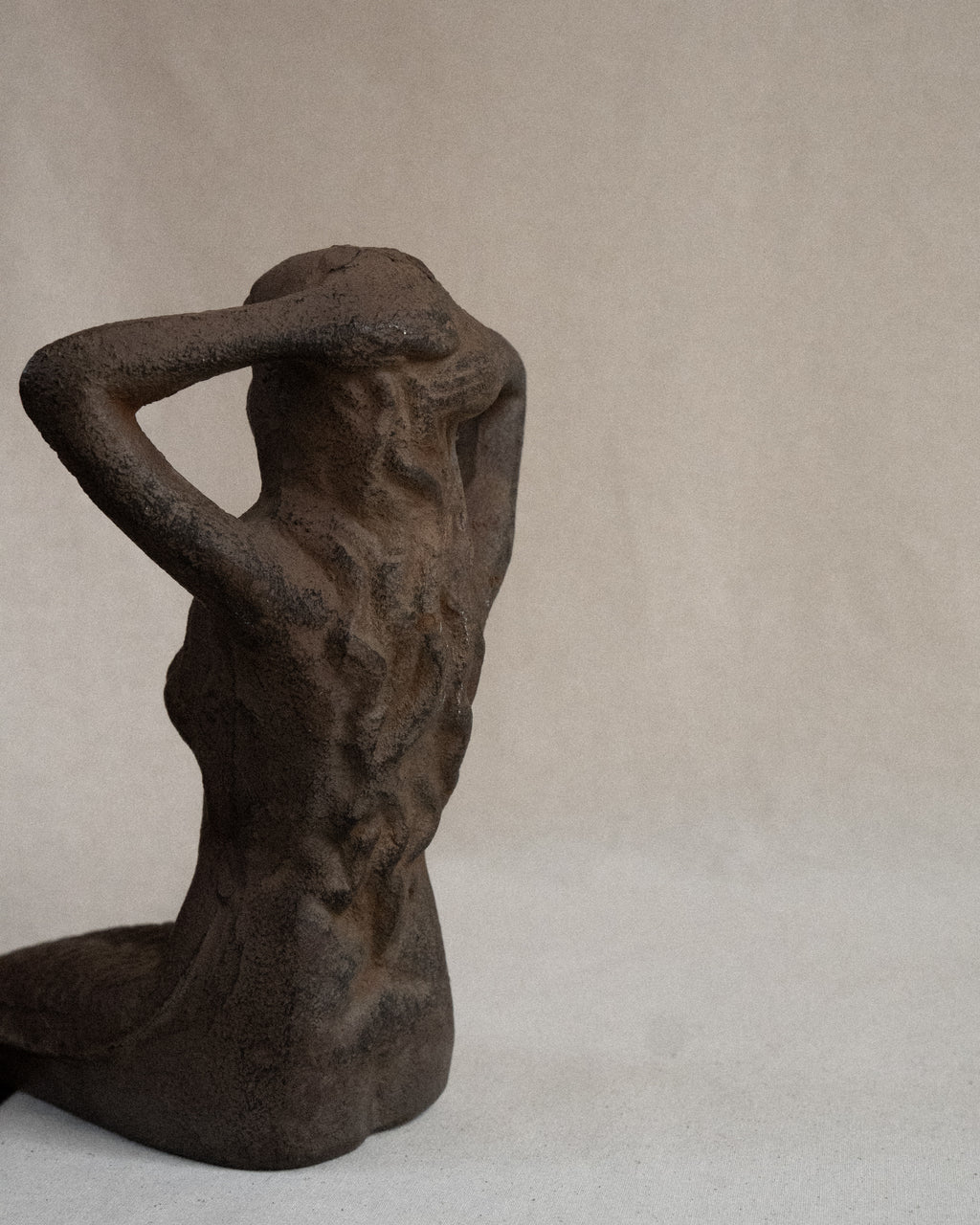 Edge-sitting cast iron mermaid sculpture