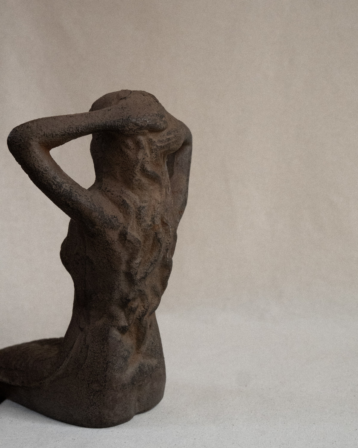 Edge-sitting cast iron mermaid sculpture
