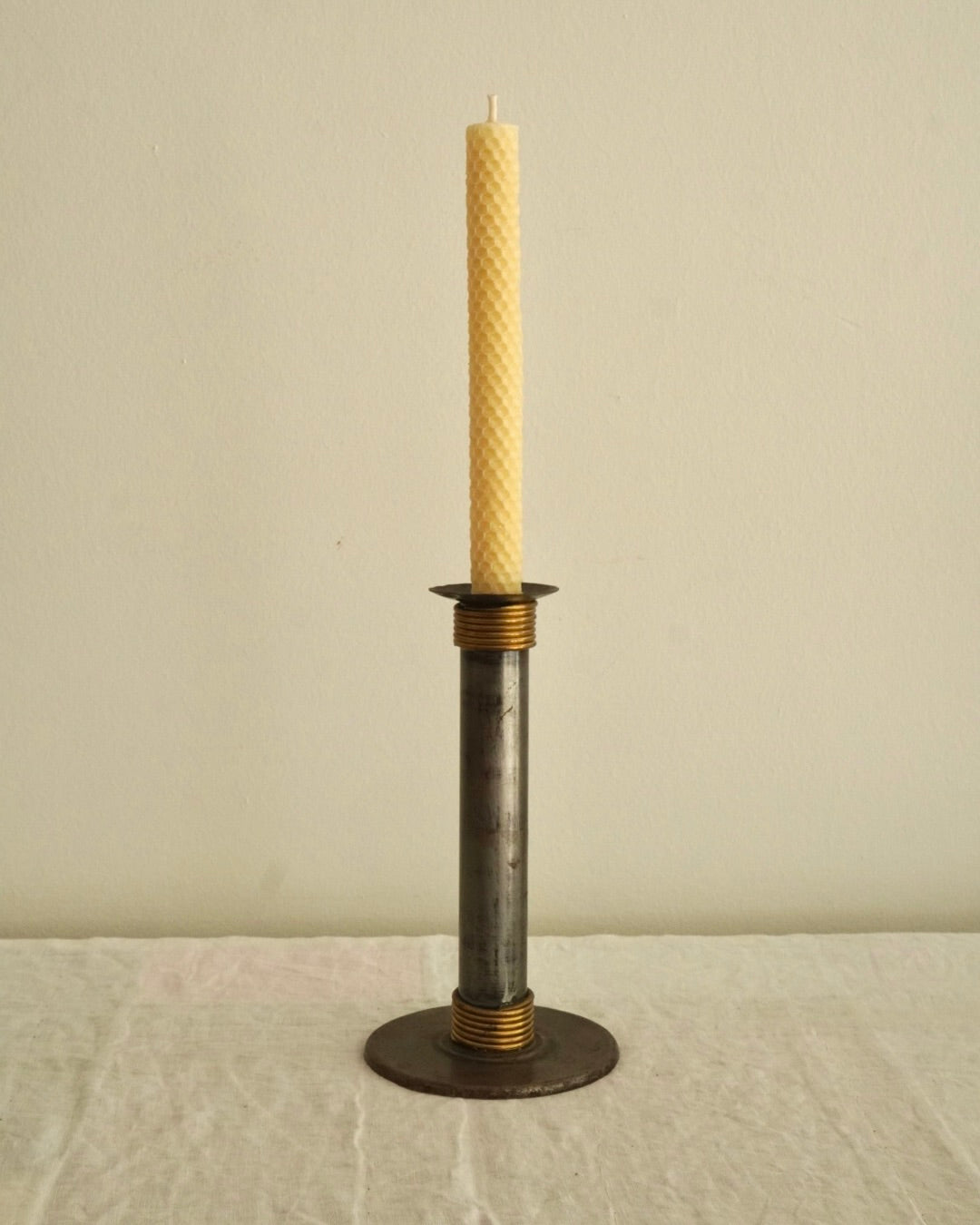 Metal candle holder with brass wrapped around