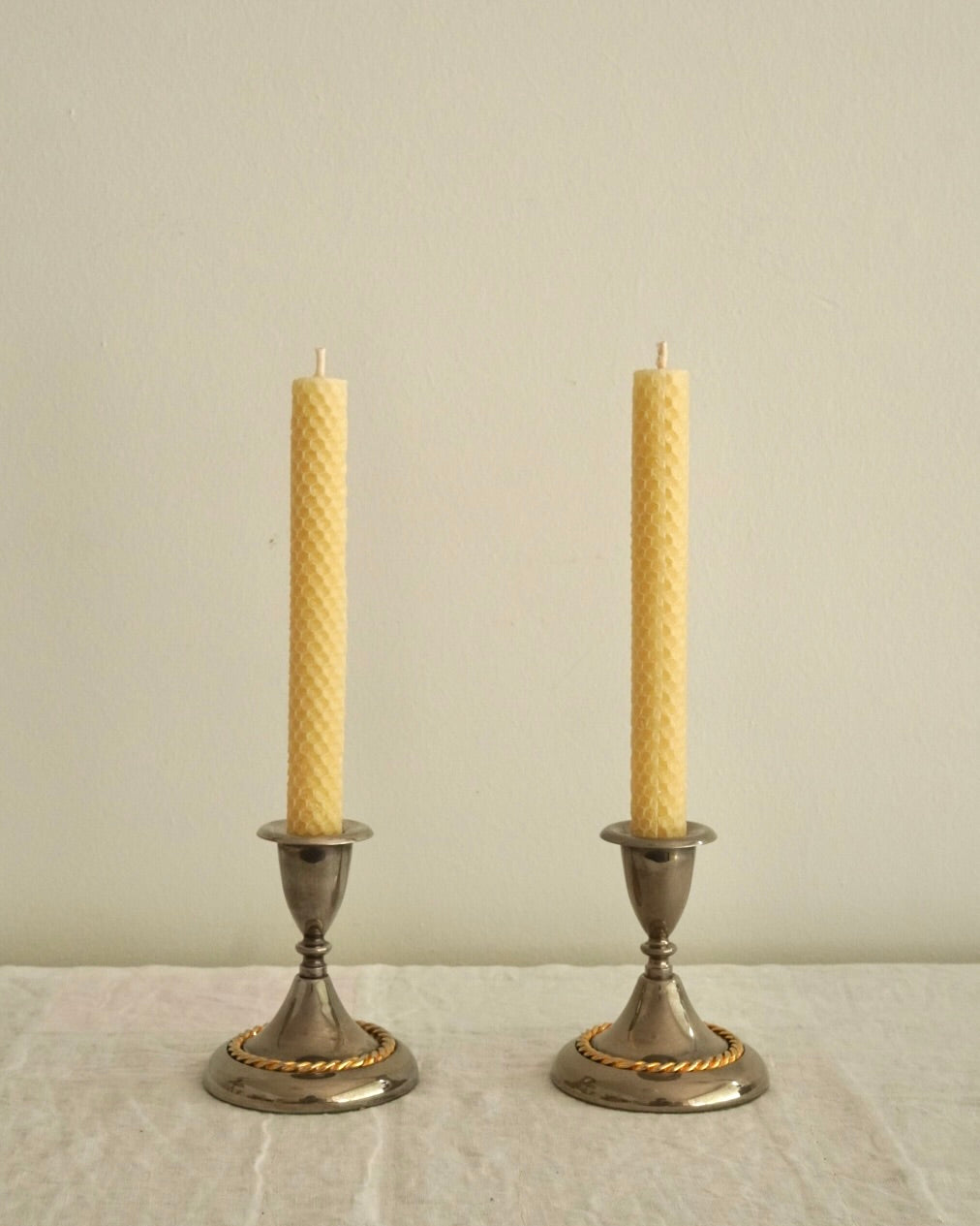Pair of silver plated candle holders with gold and silver rope detailing