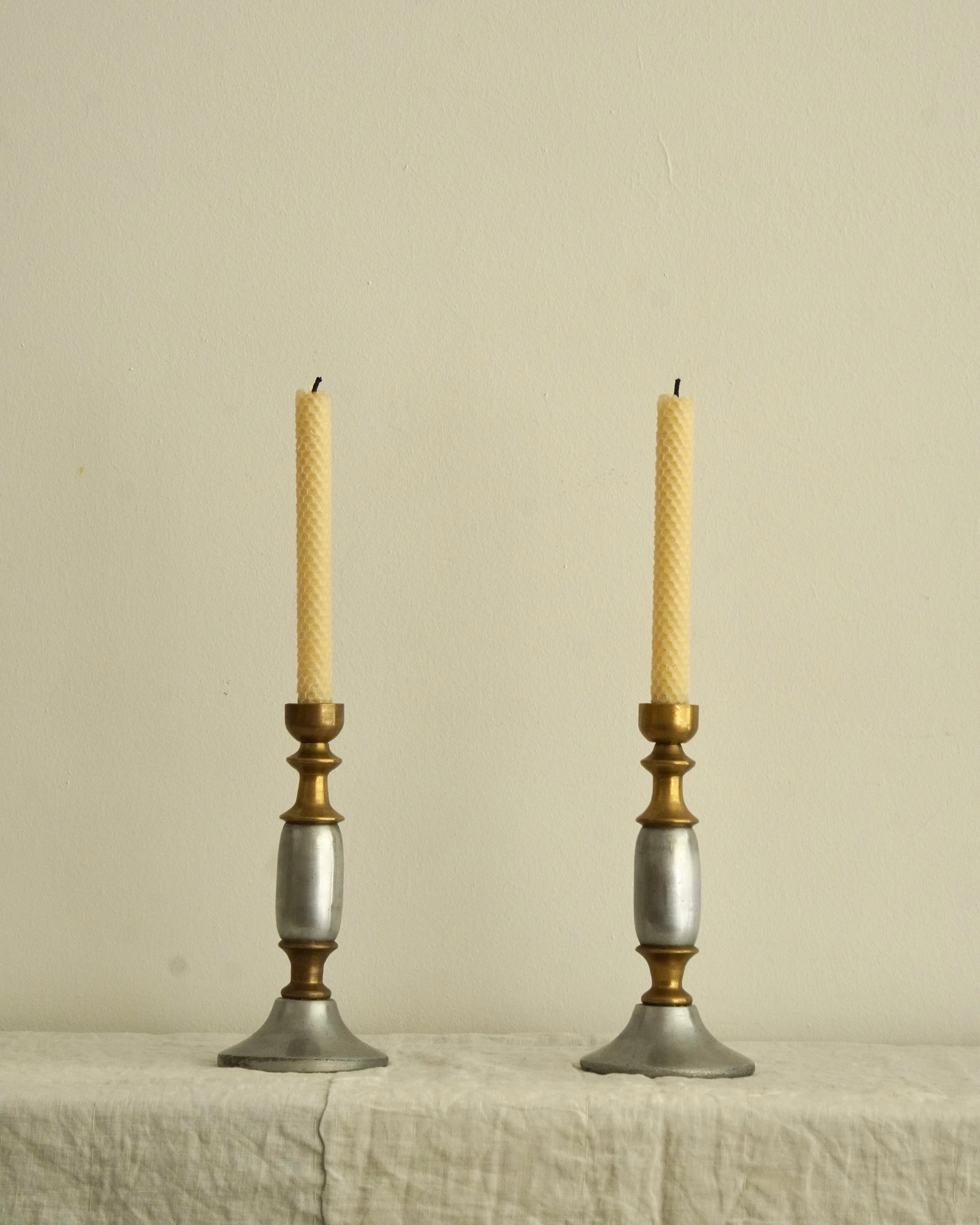 Pair of solid metal candle holders in gold and silver
