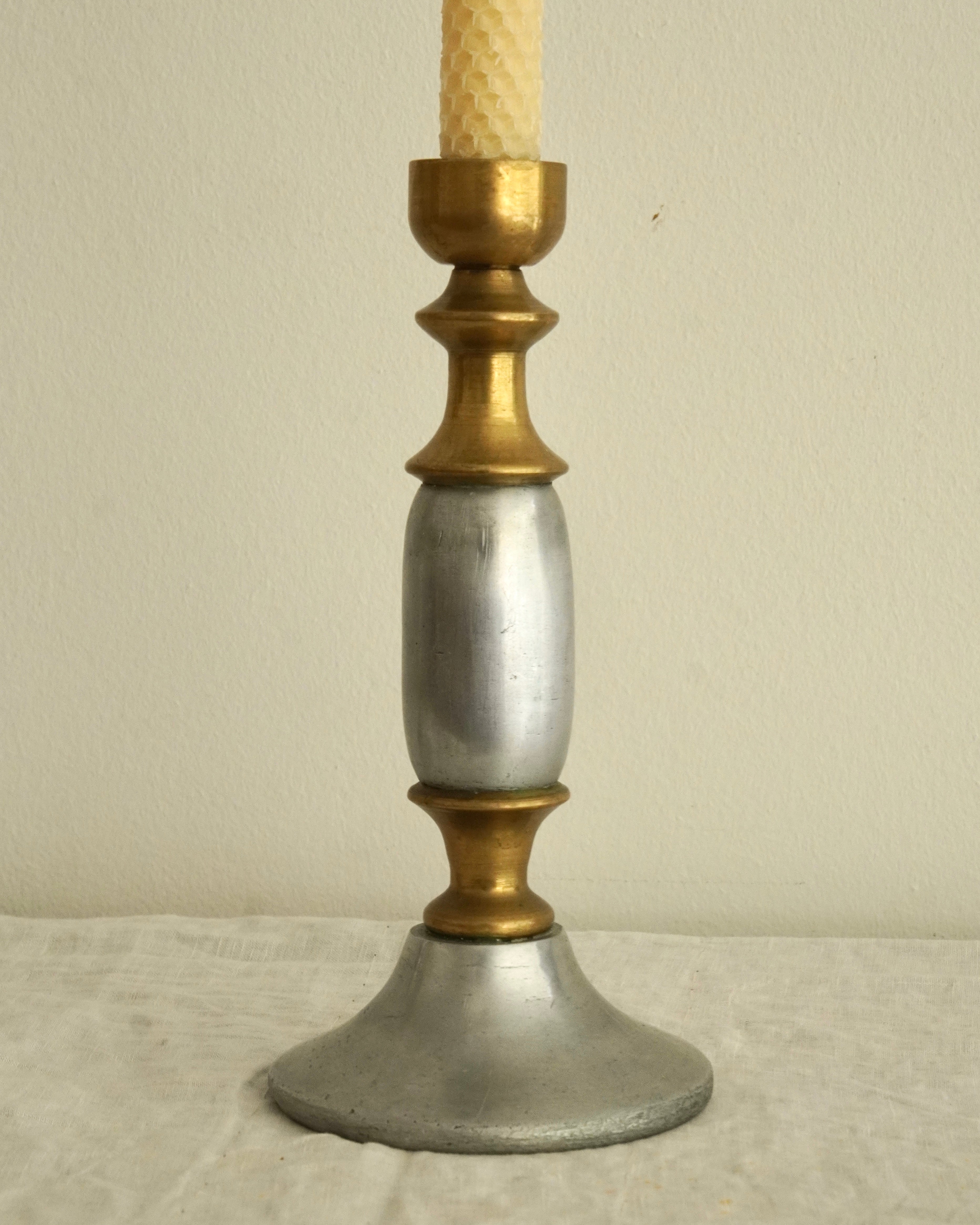 Pair of solid metal candle holders in gold and silver