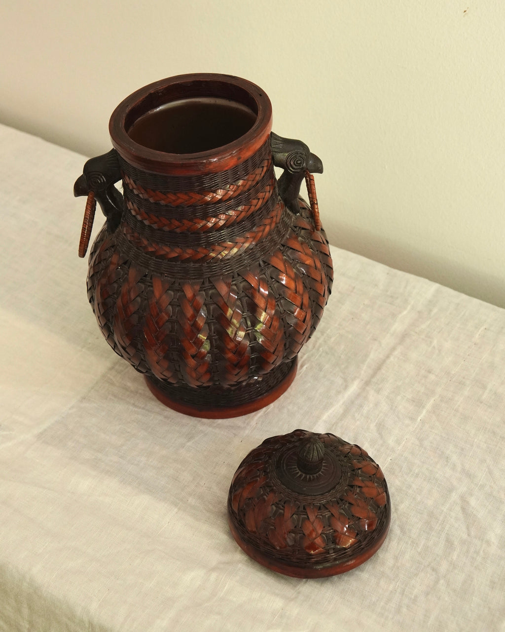 Woven basket with lid, carved wood bird handles and copper vase insert