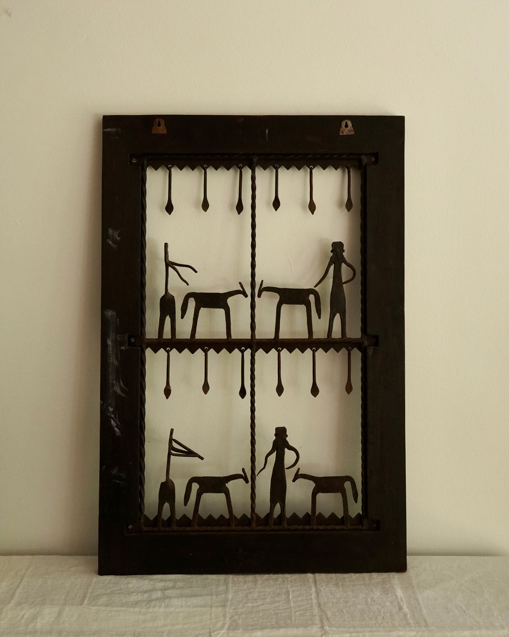 Ethnographic wall mounted panel featuring wrought iron animal and human figures