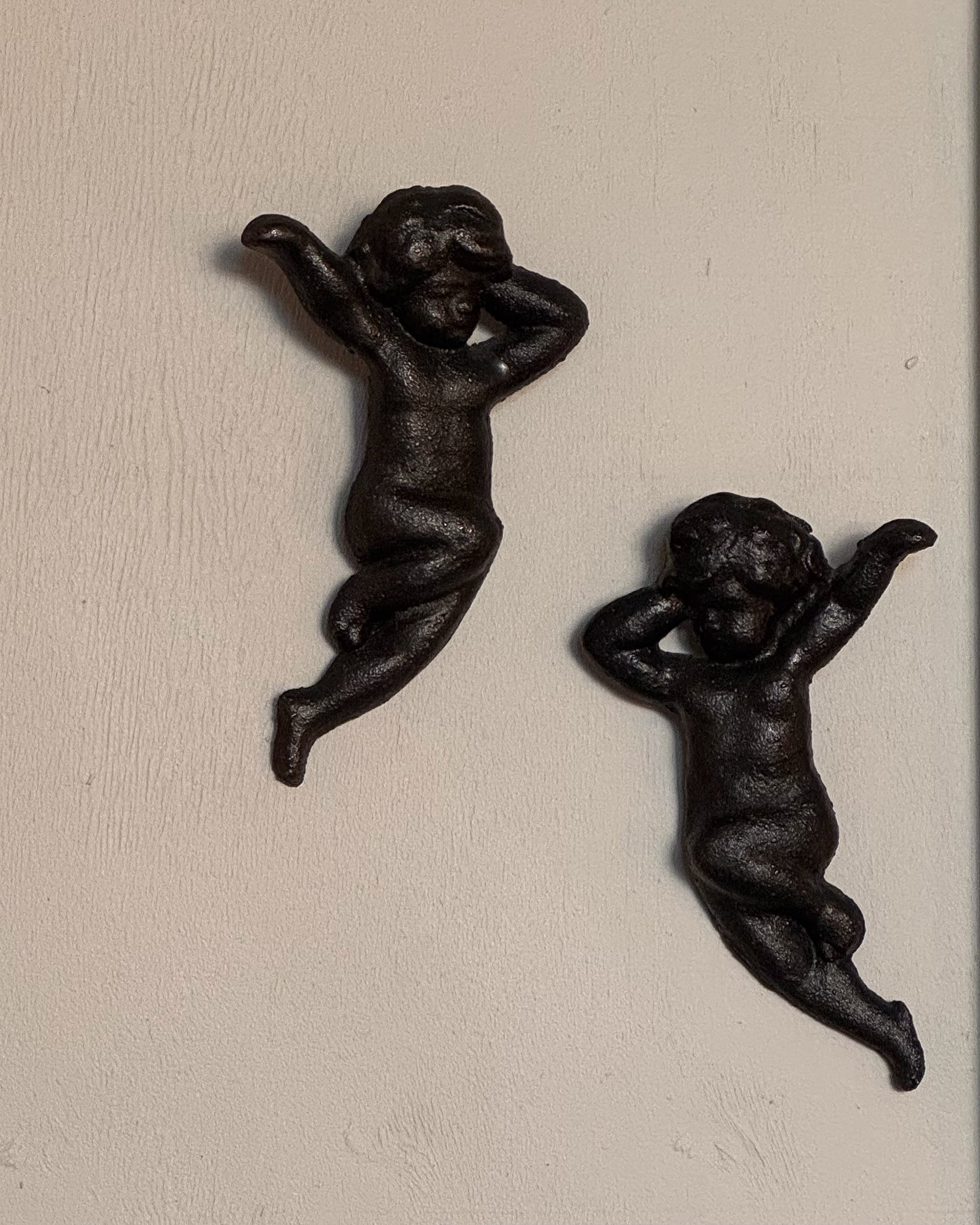 Pair of cast iron angel wall hangings