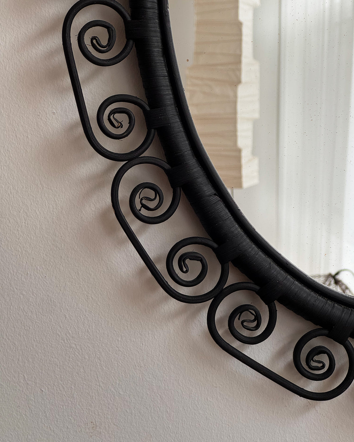 Woven rattan mirror with spiral edges in black