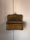 Brass wall hanging container with two individuals carrying a sedan chair