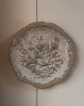 Concrete wall hanging of cherubs playing a lyre harp
