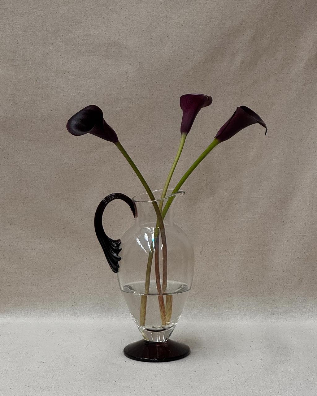 Glass pitcher vase with star like dark purple handle